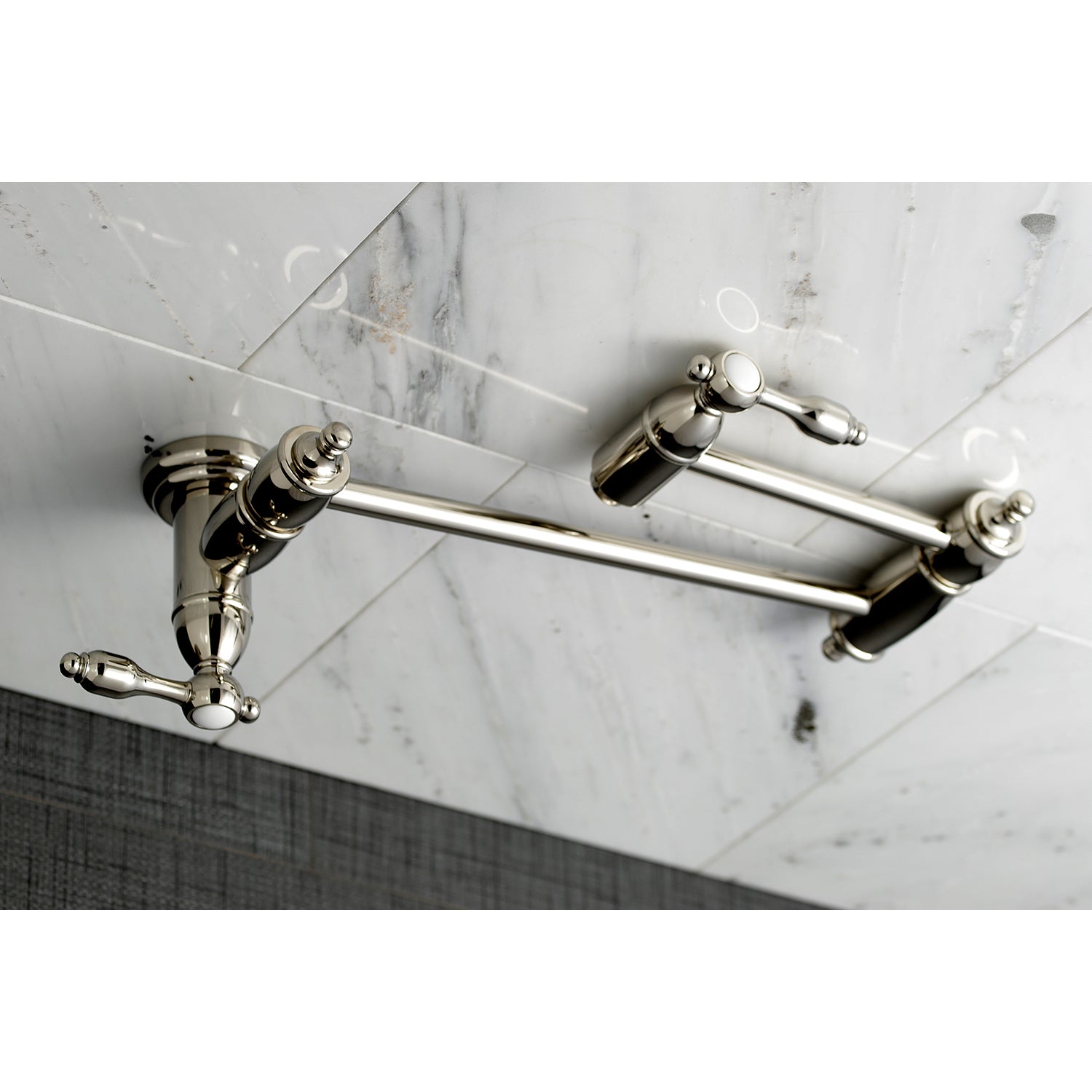 Kingston Brass KS3103TAL Tudor Wall Mount Pot Filler Faucet, Antique Brass on a marble backsplash.