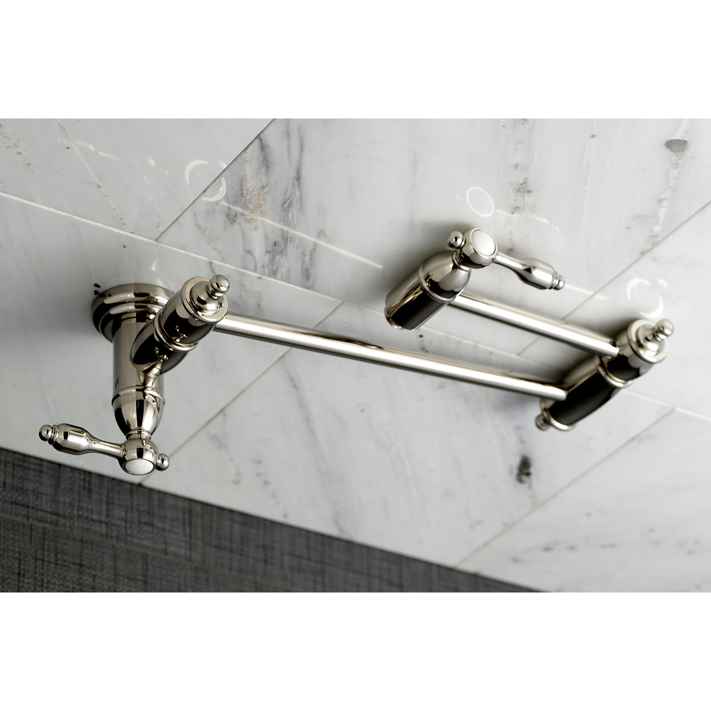 Kingston Brass KS3103TAL Tudor Wall Mount Pot Filler Faucet, Antique Brass on a marble backsplash.