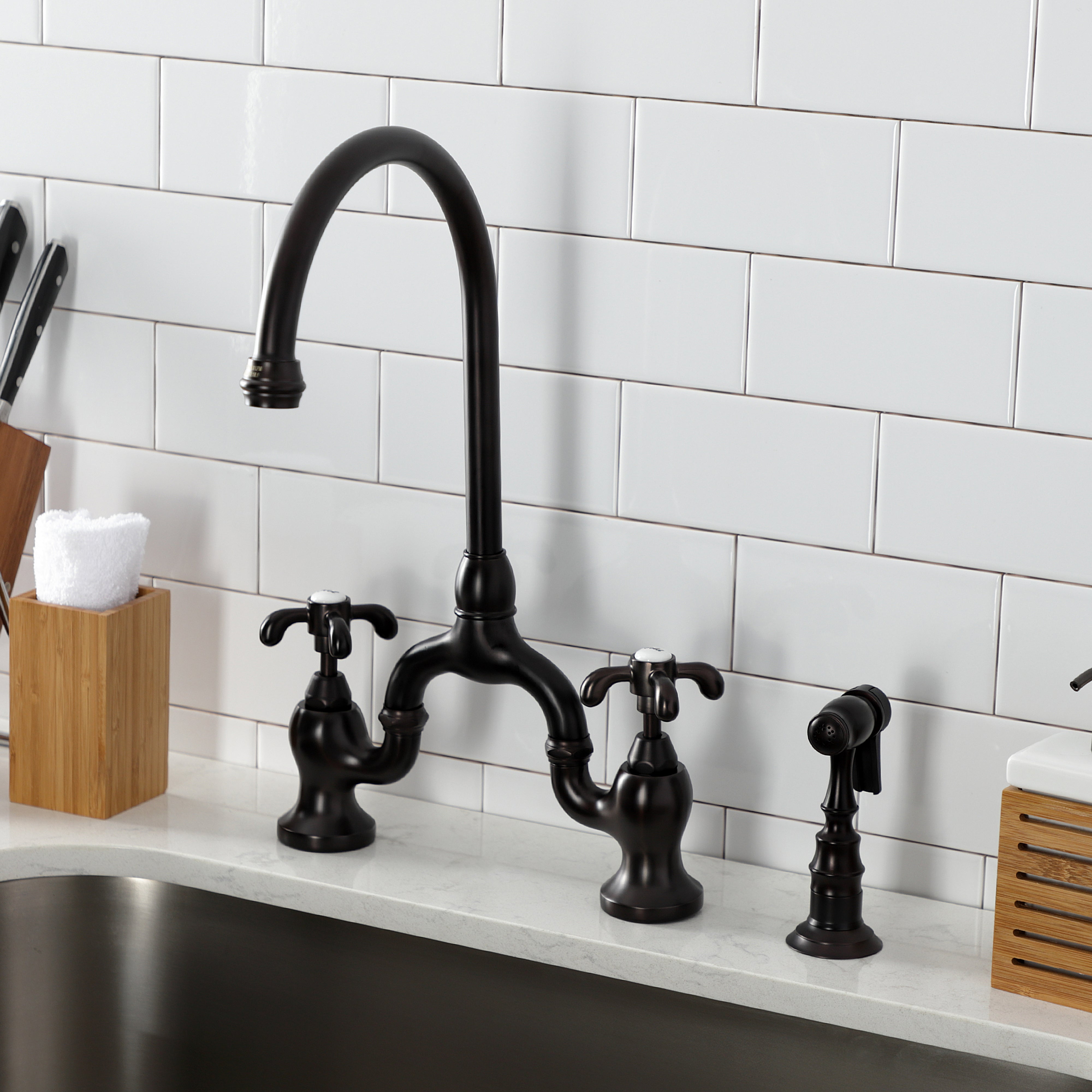 Kingston KS7793TXBS French Country Bridge Kitchen Faucet with Brass Sprayer, Antique Brass in elegant kitchen setting.
