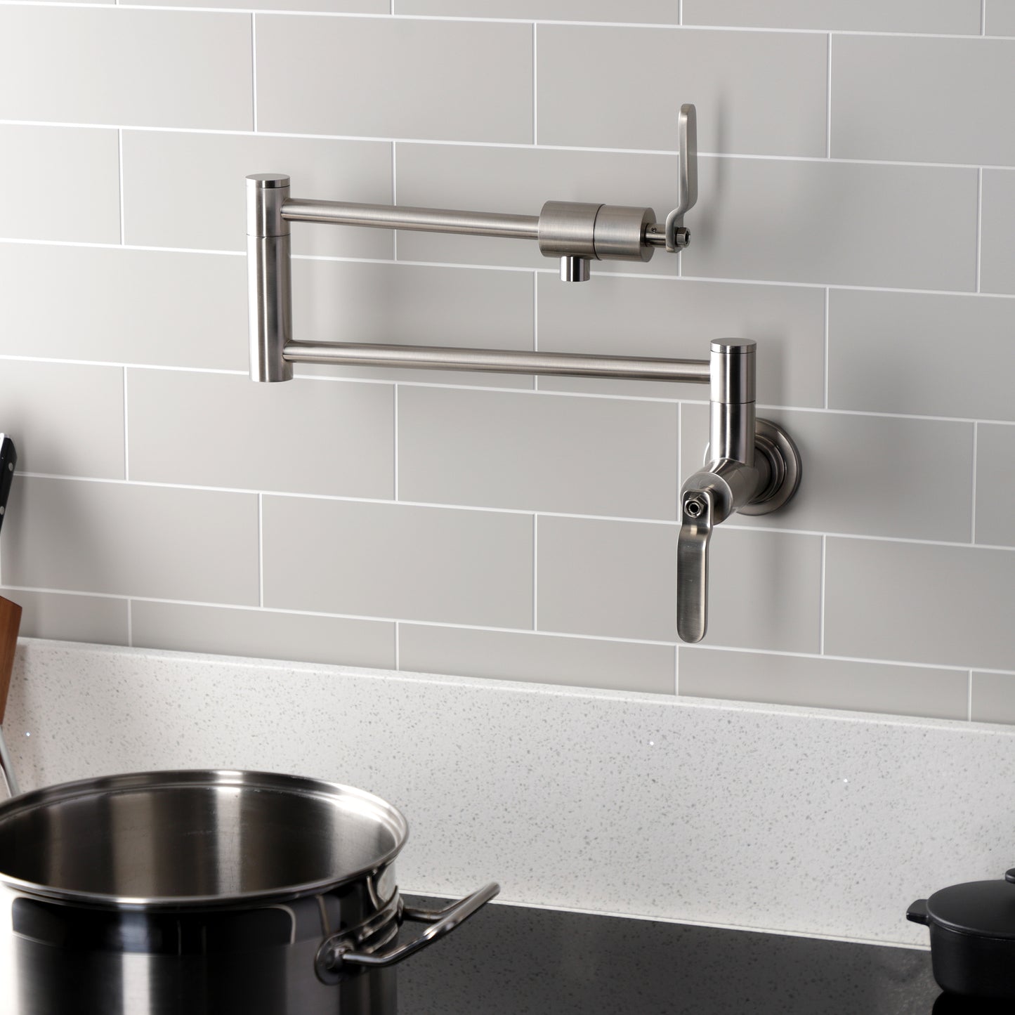 Kingston Brass KS4103KL Whitaker Wall Mount Pot Filler Faucet, Antique Brass in modern kitchen setting.