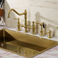 Kingston KS3277ALBS Restoration Bridge Kitchen Faucet with Brass Sprayer, Brushed Brass installed in a modern kitchen setup.