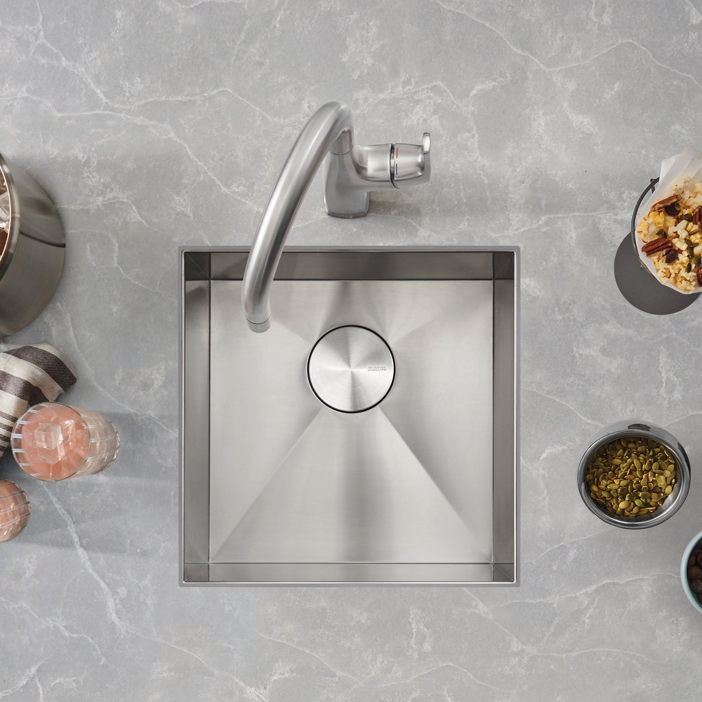 BLANCO Quatrus R0 17" Stainless Steel Undermount Bar Sink with modern faucet and surrounding decorative items.