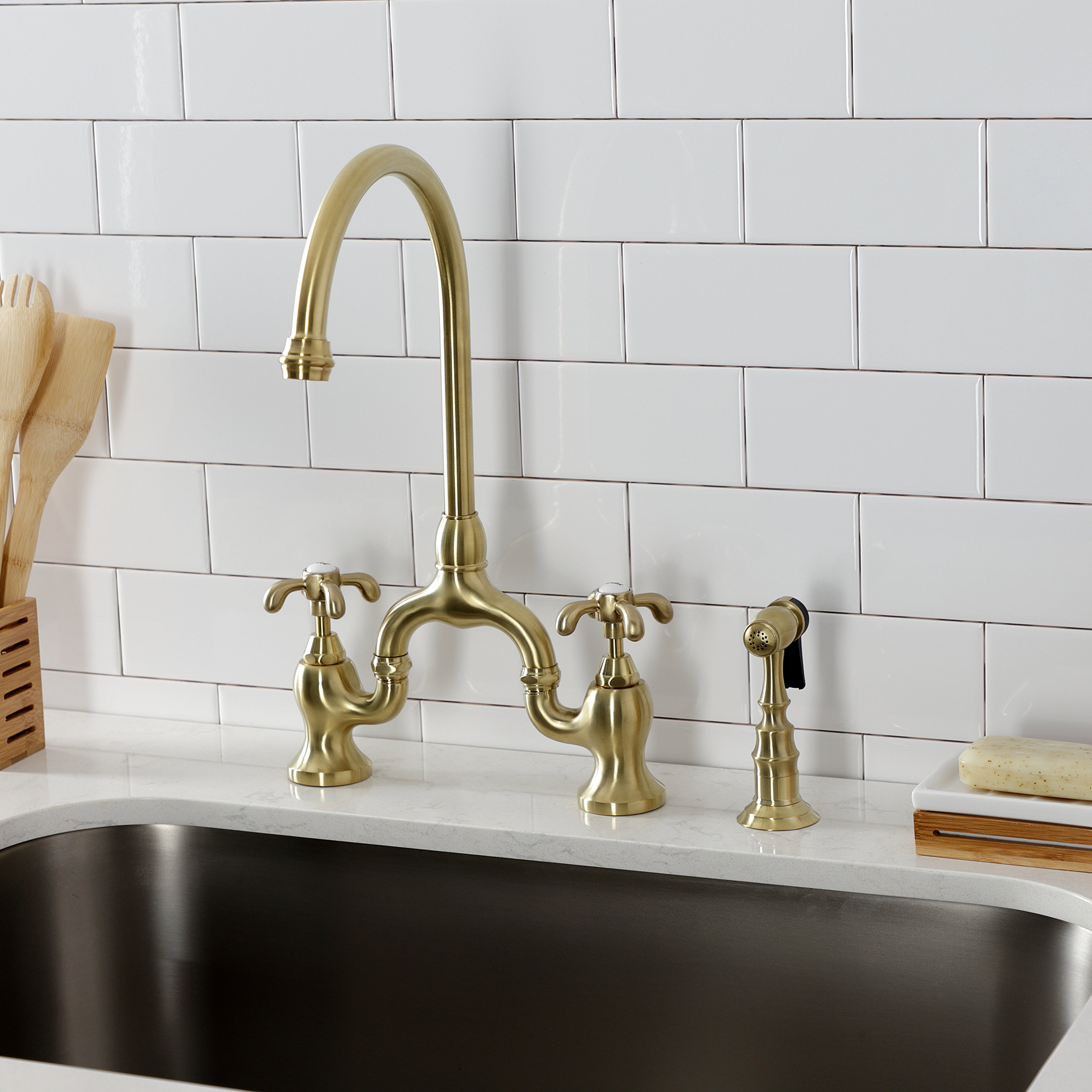 Kingston KS7793TXBS French Country Bridge Kitchen Faucet with Brass Sprayer, Antique Brass in a kitchen setting.
