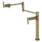 Kingston Brass KS4703CML Manhattan Deck Mount Pot Filler Faucet, Antique Brass with swing arms on a white background.