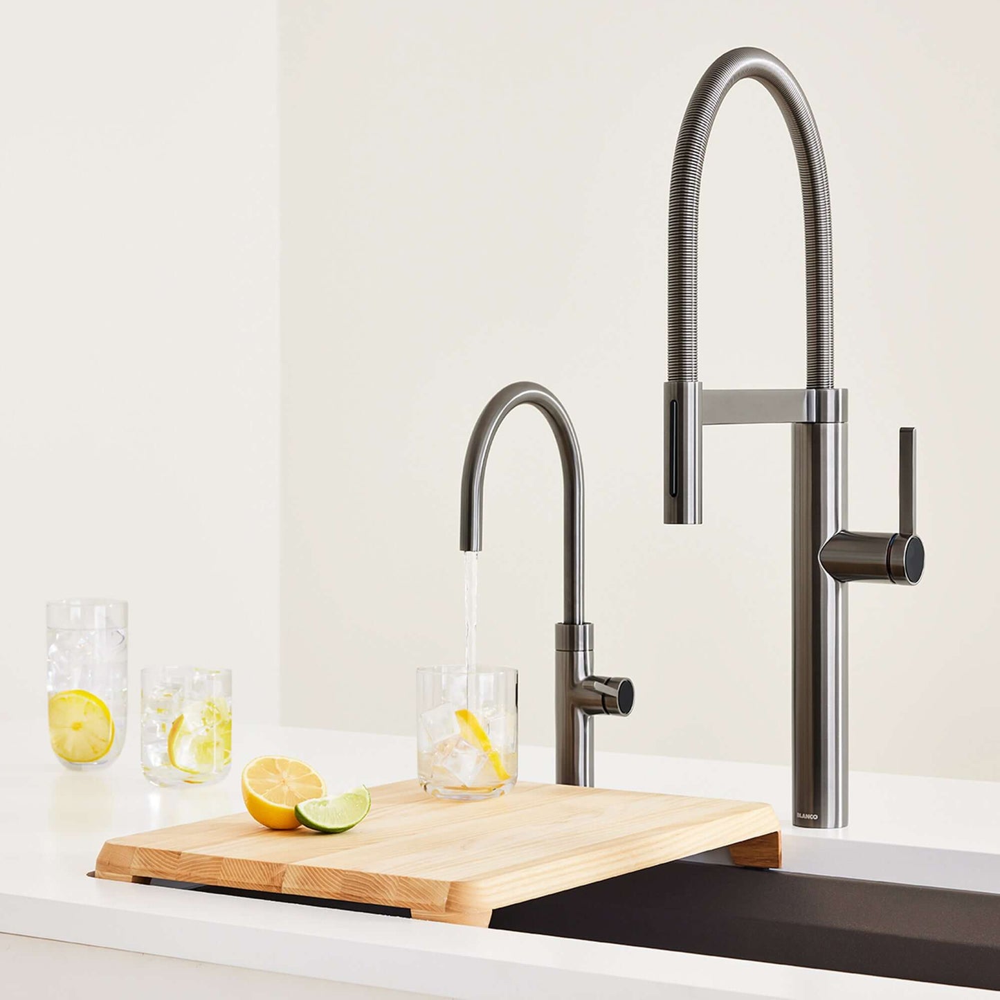 BLANCO Culina II High Arc Beverage Faucet Compatible with Reverse Osmosis Systems pouring water into a glass with ice.