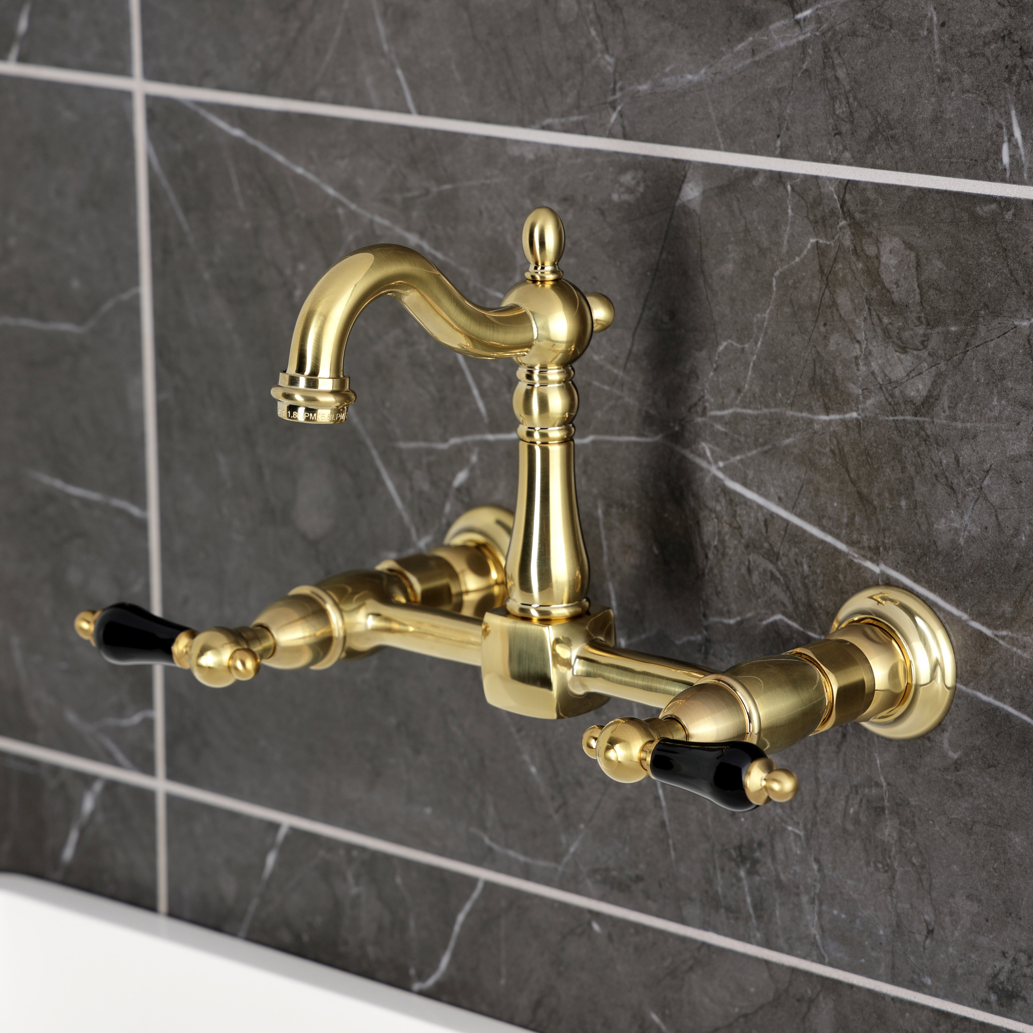 Kingston KS2443PKL Duchess Two-Handle Wall Mount Bridge Kitchen Faucet, Antique Brass on a modern kitchen backsplash.