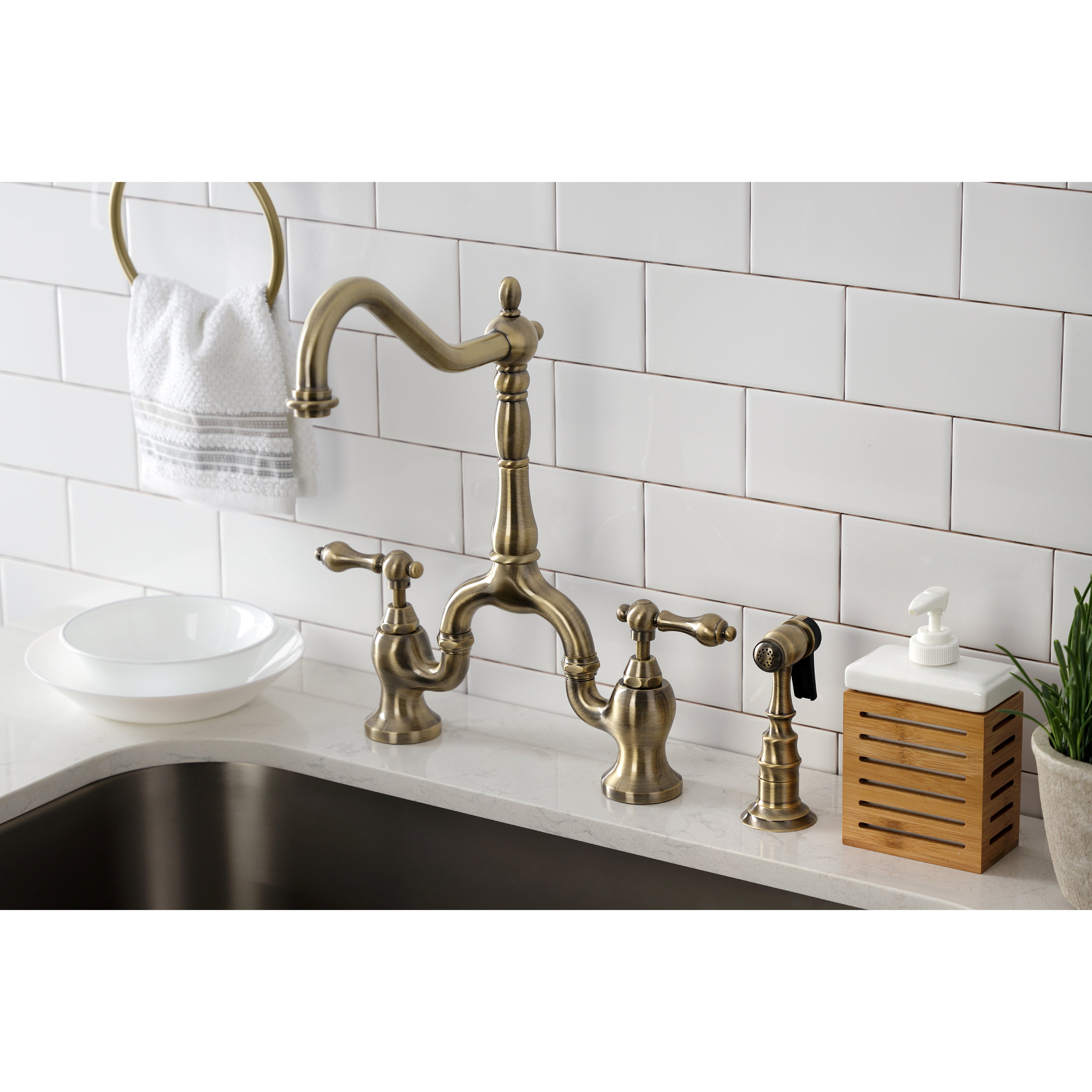 Kingston KS7753ALBS English Country Bridge Kitchen Faucet with Brass Sprayer, Antique Brass in a kitchen setting