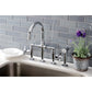 Kingston KS2333NX Hamilton Industrial Style Bridge Kitchen Faucet with Brass Sprayer, Antique Brass in a modern kitchen setting.