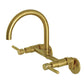 Kingston Brass KS814SB Concord Wall Mount Bridge Kitchen Faucet with gooseneck spout and dual side handles in brushed brass finish.