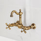 Kingston KS2443AX Heritage Two-Handle Wall Mount Bridge Kitchen Faucet, Antique Brass on a marble background