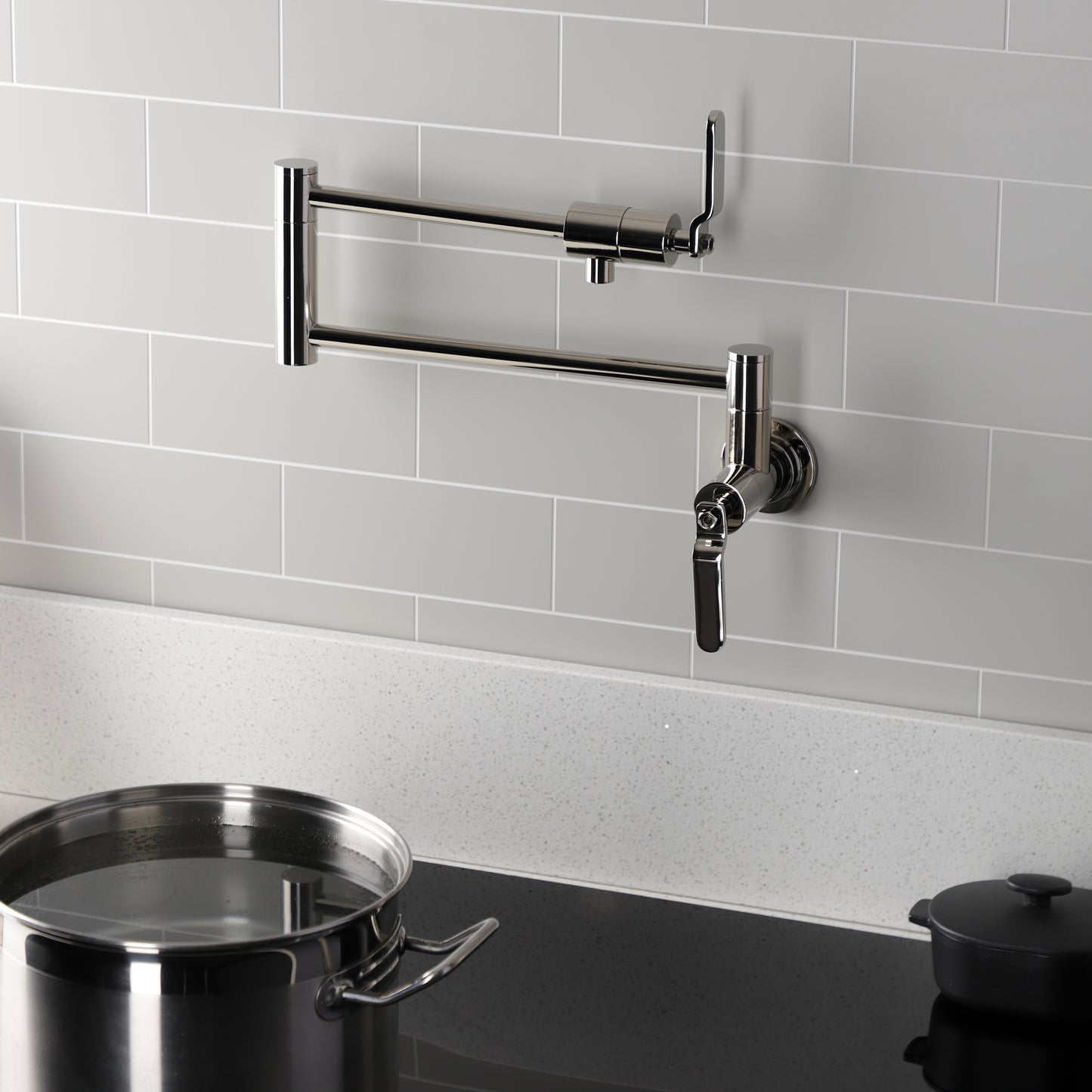 Kingston Brass KS4103KL Whitaker Wall Mount Pot Filler Faucet, Antique Brass with foldable swing arms in kitchen.