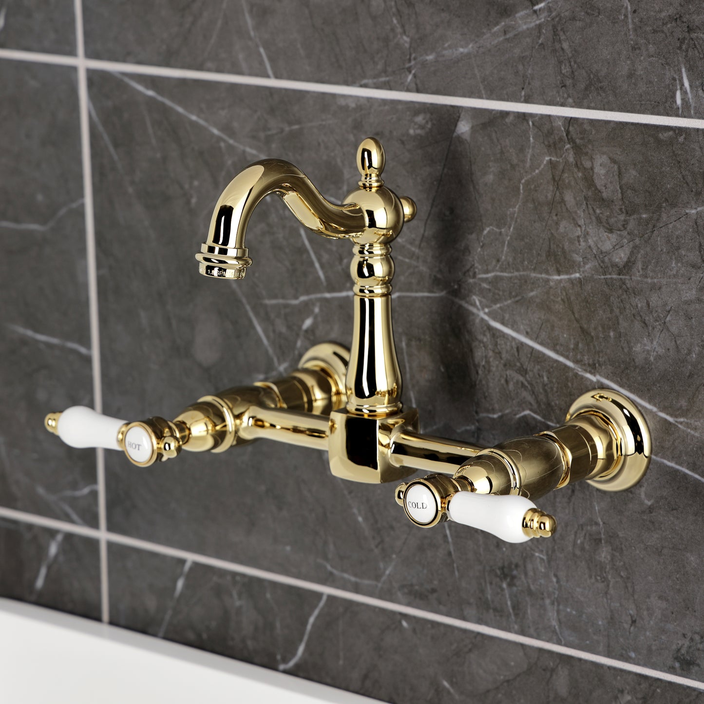 Kingston KS2443BPL Bel-Air Two-Handle Wall Mount Bridge Kitchen Faucet, Antique Brass on a stylish wall.