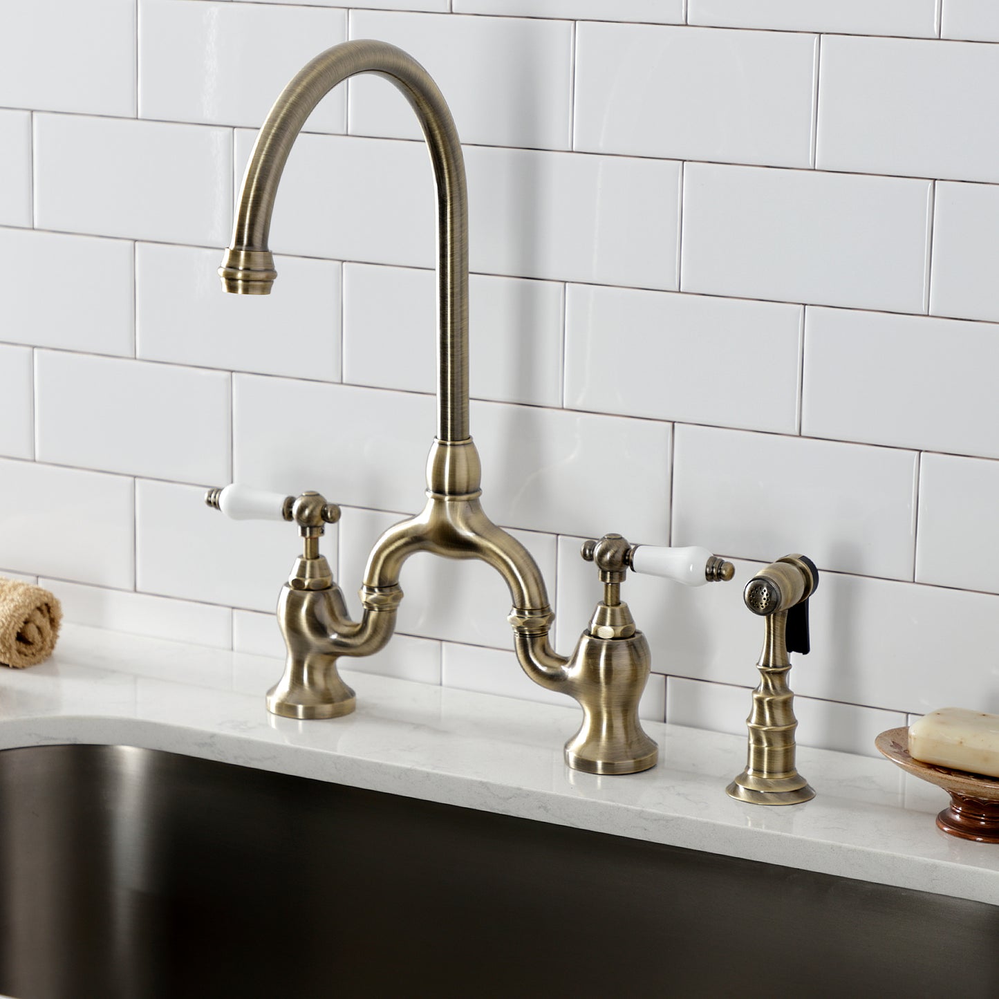 Kingston KS7793PLBS English Country Bridge Kitchen Faucet with Brass Sprayer, Antique Brass in a kitchen setting.
