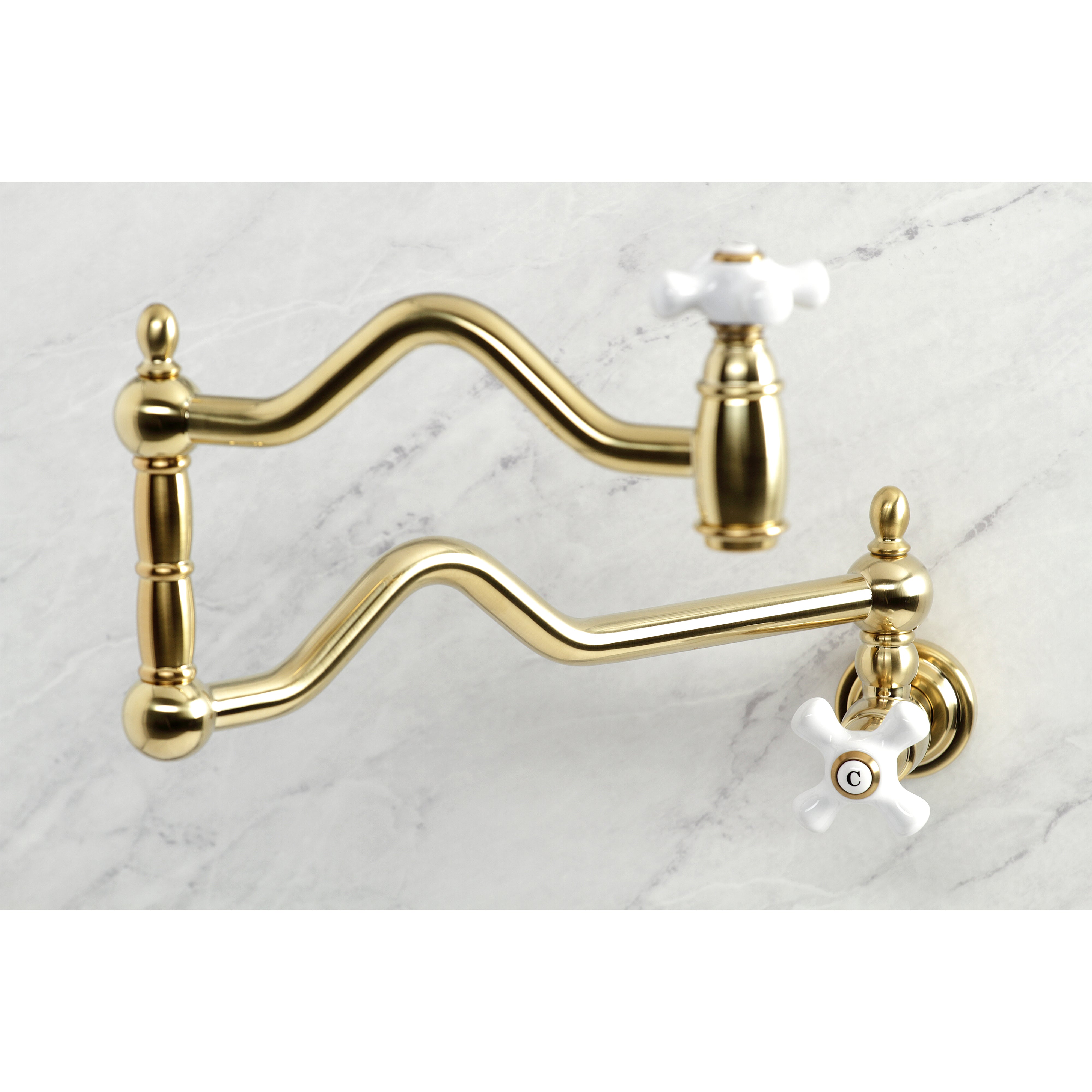 Kingston Brass KS2107PX Heritage Wall Mount Pot Filler Faucet, Brushed Brass on a marble surface
