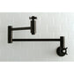 Kingston Brass KS8103ZX Millennium Wall Mount Pot Filler Faucet, Antique Brass on a white tiled wall.