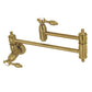 Kingston Brass KS3103TAL Tudor Wall Mount Pot Filler Faucet, Antique Brass with brushed brass finish.