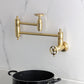 Kingston Brass KS3103RKX Webb Wall Mount Pot Filler Faucet with Knurled Handle, Antique Brass in kitchen setting.