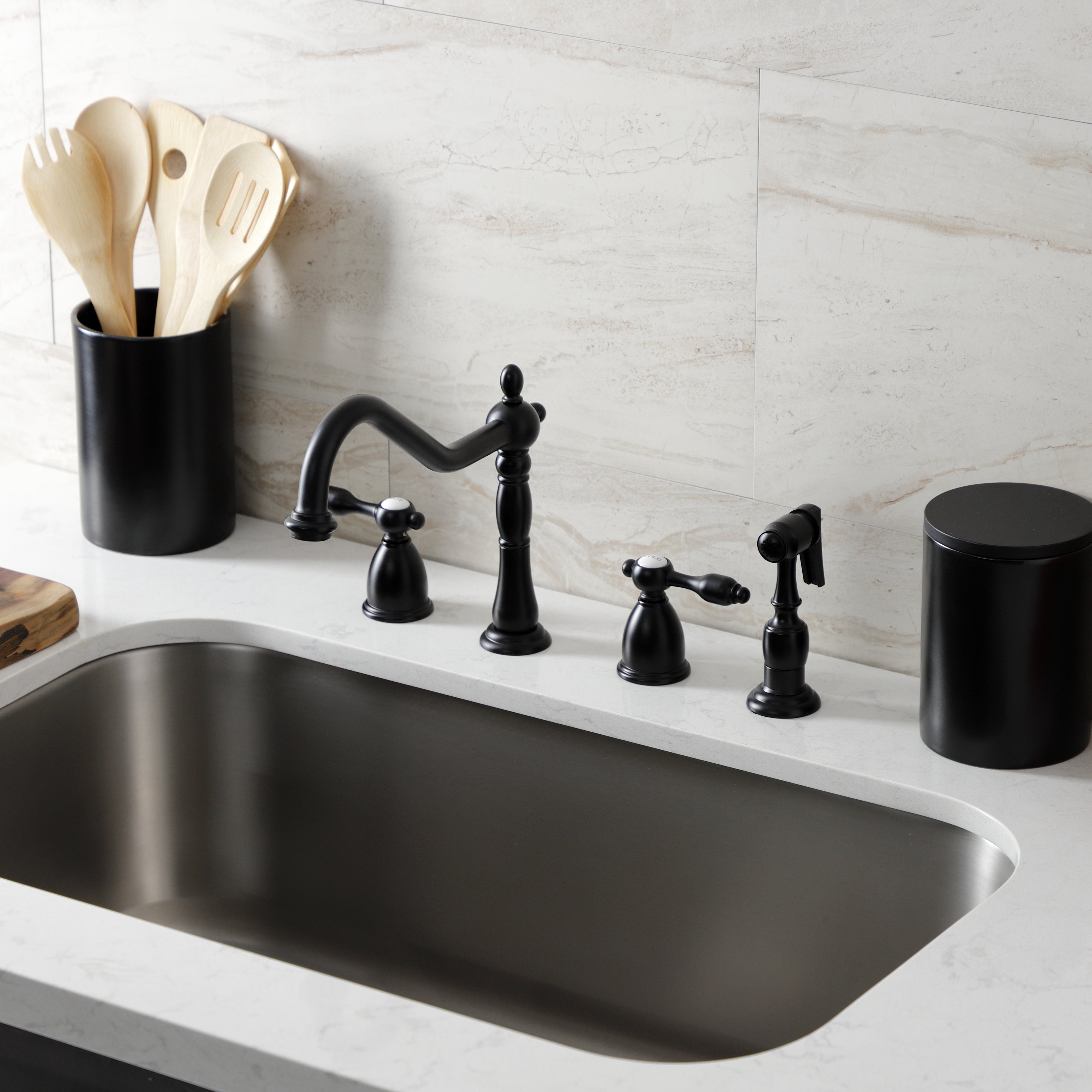 Kingston Brass KB1797TALBS Tudor Double-Handle Widespread Kitchen Faucet with Brass Sprayer, Brushed Brass in a modern kitchen setting.