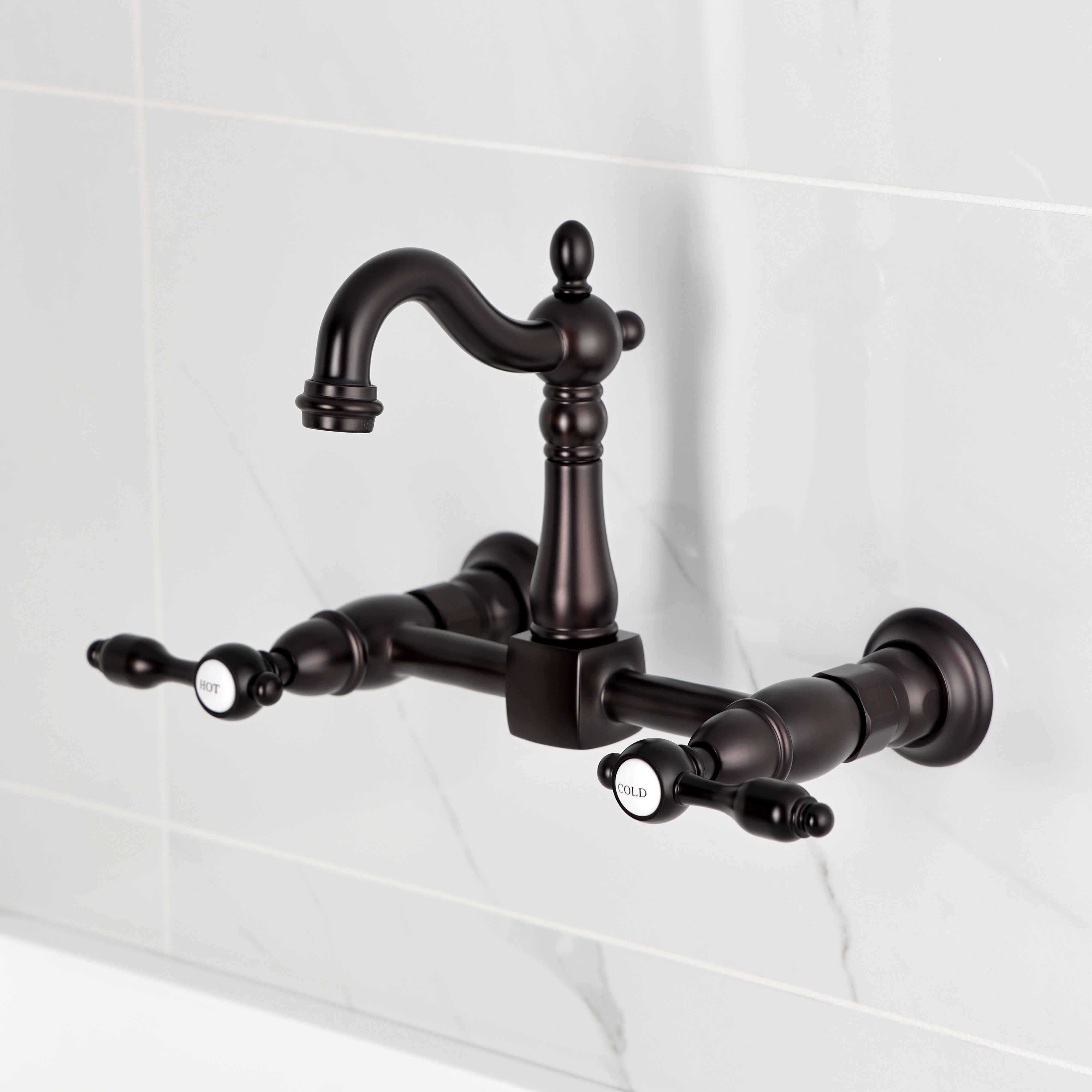 Kingston KS2443TAL Tudor Two-Handle Wall Mount Bridge Kitchen Faucet, Antique Brass design on marble background