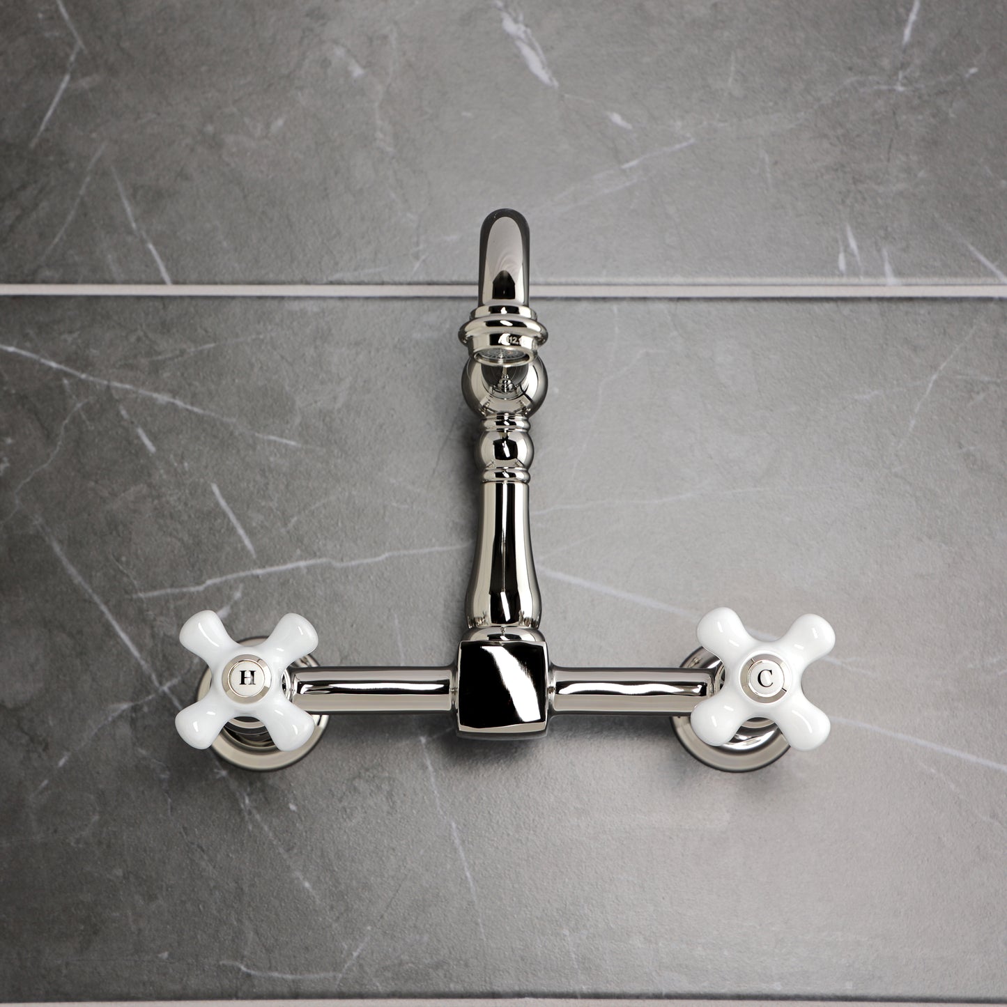 Kingston KS1263PX Heritage Two-Handle Wall Mount Bridge Kitchen Faucet, Antique Brass on a sleek gray backdrop.