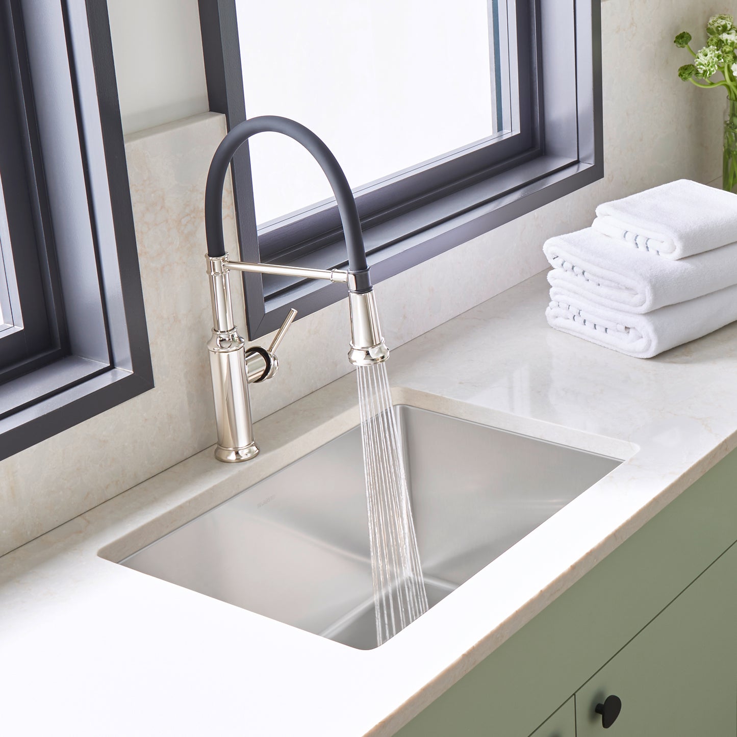 BLANCO Quatrus R15 25" Single Bowl Dual Mount Stainless Steel Laundry Sink with faucet and clean towels in background.