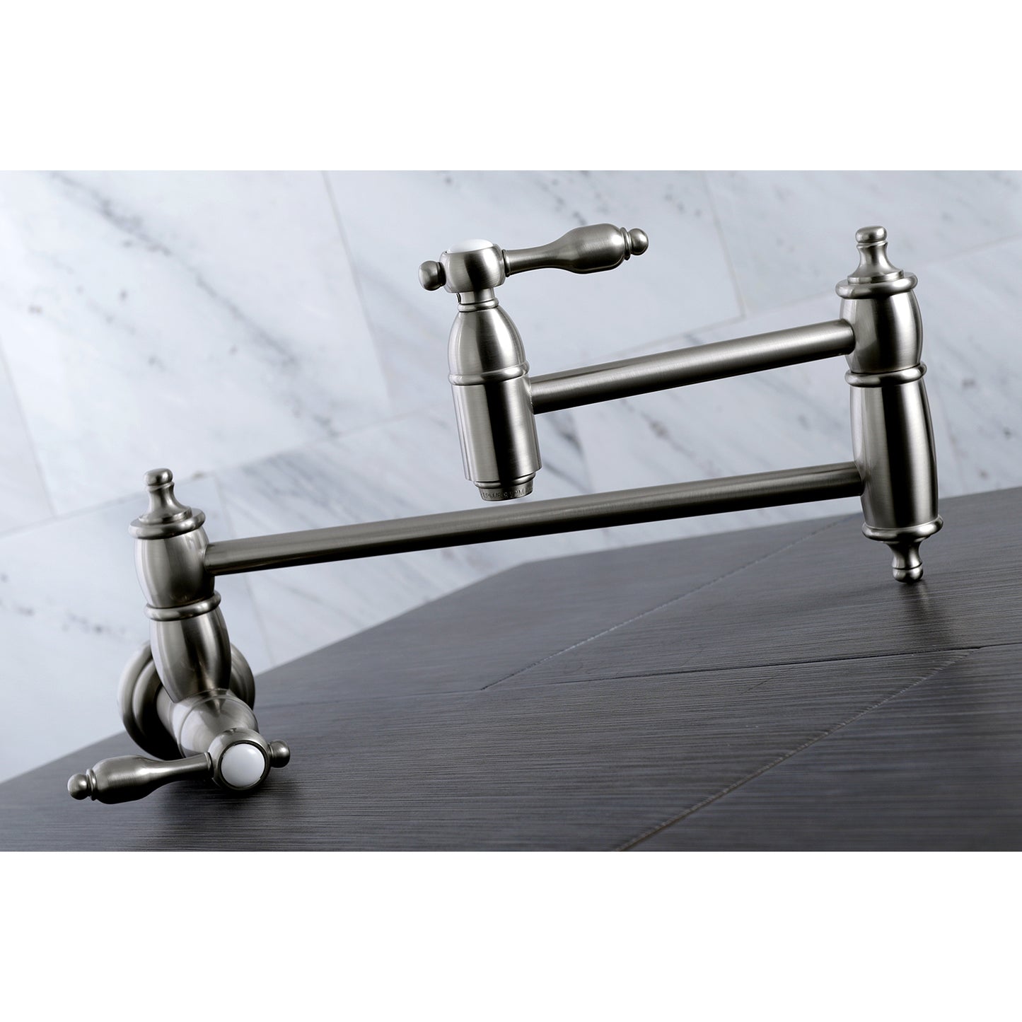 Kingston Brass KS3103TAL Tudor Wall Mount Pot Filler Faucet, Antique Brass close-up view on a kitchen countertop.