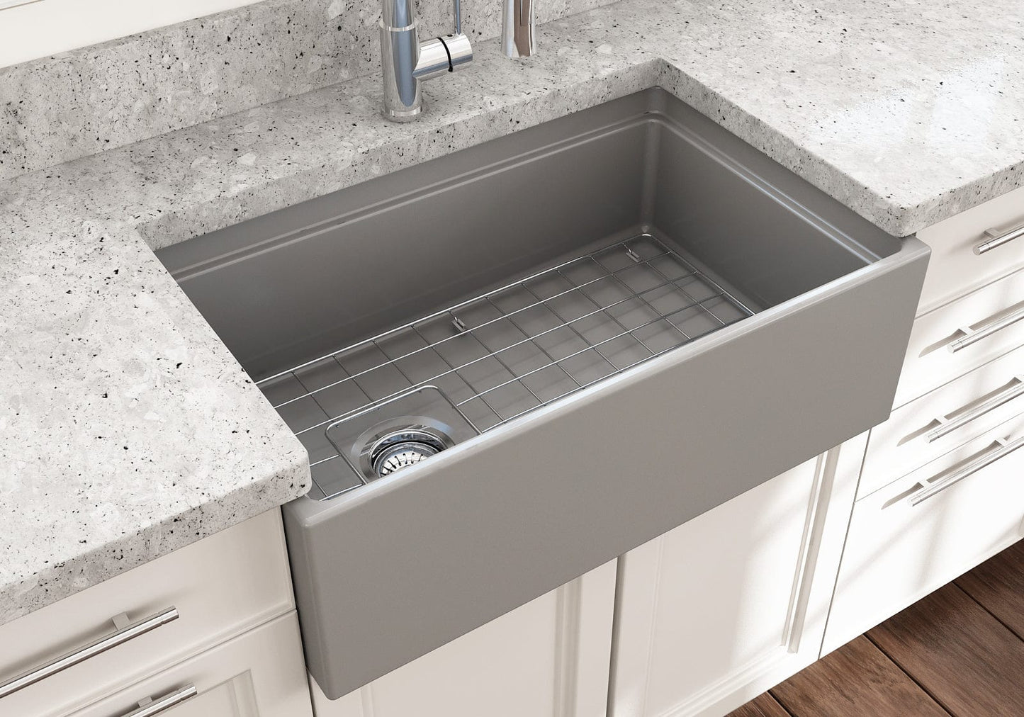 Side angle of a matte gray BOCCHI Contempo 30" fireclay farmhouse sink highlighting offset drain, chrome strainer and stainless steel bottom grid.