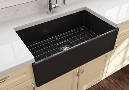 Lifestyle image of the Bocchi Contempo 33" Fireclay Farmhouse Sink in Matte Black, showing included stainless steel bottom grid and strainer