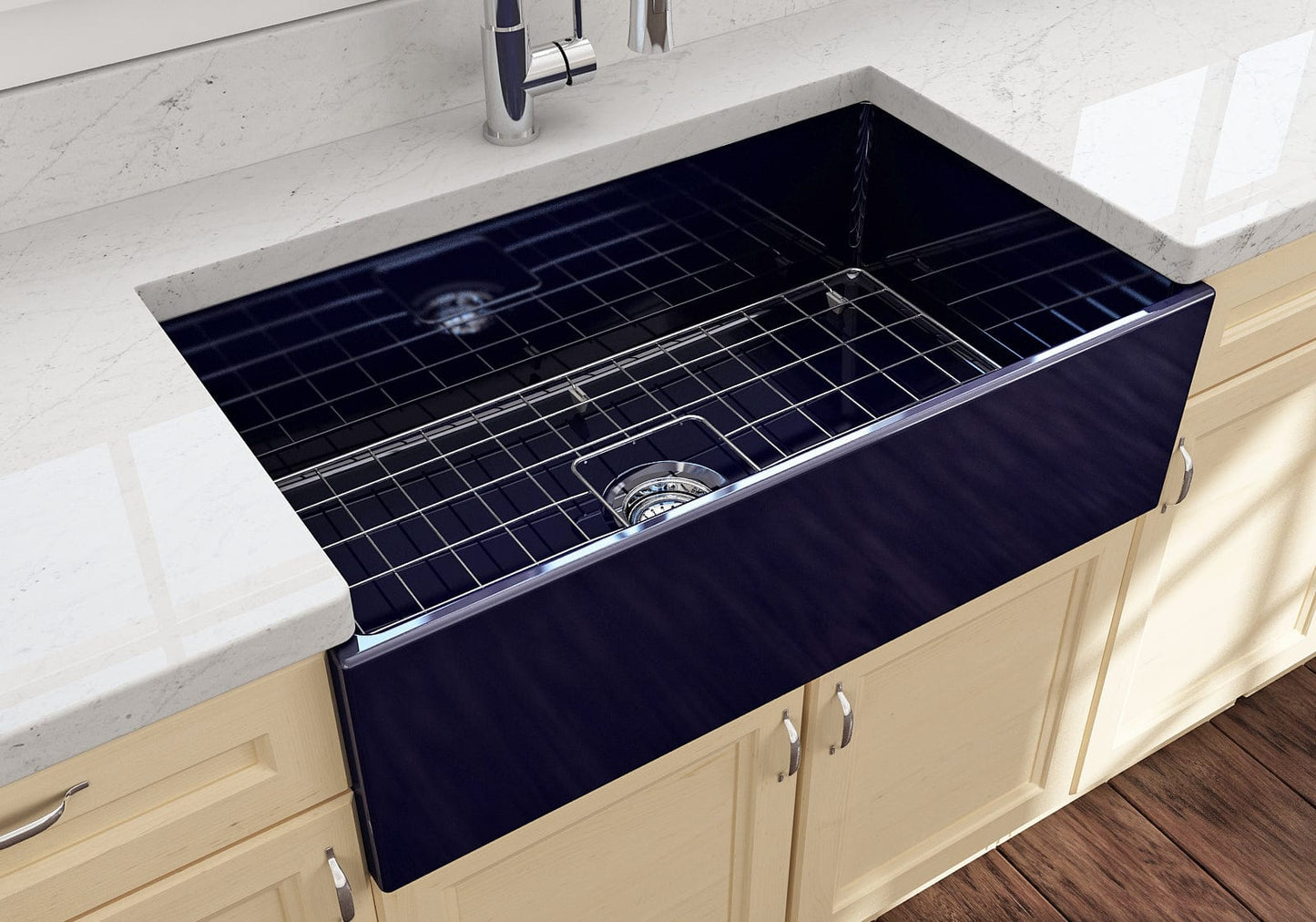 Lifestyle image of the Bocchi Contempo 33" Fireclay Farmhouse Sink in Sapphire Blue, showing included stainless steel bottom grid and strainer