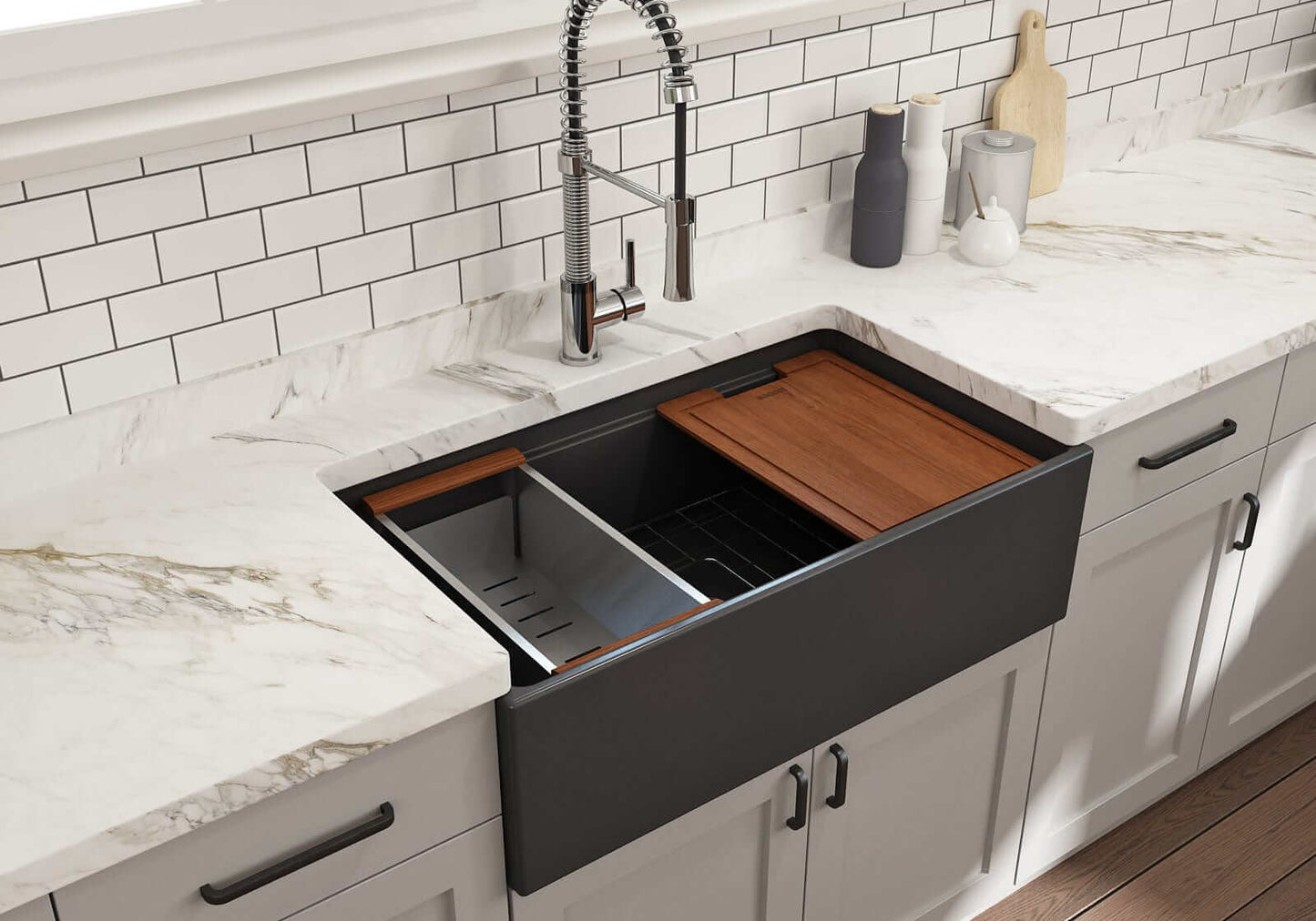 Lifestyle image of matte dark gray step-rim BOCCHI Contempo 33" sink in a modern kitchen with colander and cutting board in use.