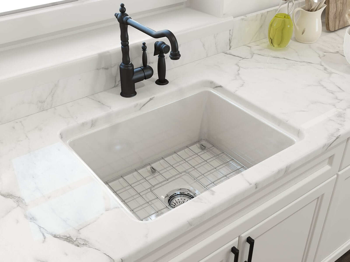 BOCCHI SOTTO 24" Fireclay Dual-Mount Single Bowl Sink with Bottom Grid & Strainer in a white kitchen with marble countertop.