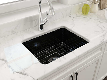 BOCCHI SOTTO 24" Fireclay Dual-Mount Single Bowl Sink with Bottom Grid & Strainer in black installed in a marble countertop.