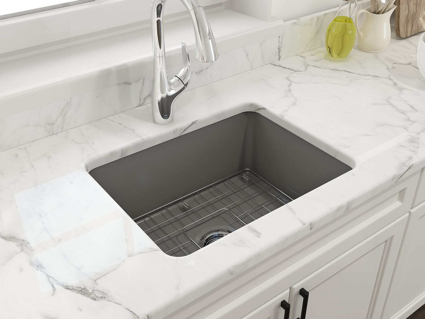 BOCCHI SOTTO 24" Fireclay Dual-Mount Single Bowl Sink with Bottom Grid & Strainer in Matte Gray on a marble countertop.