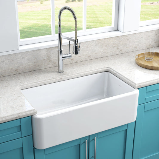 Latoscana 33" Reversible Fireclay Single Bowl Farmhouse Sink front view with modern kitchen faucet and countertop.