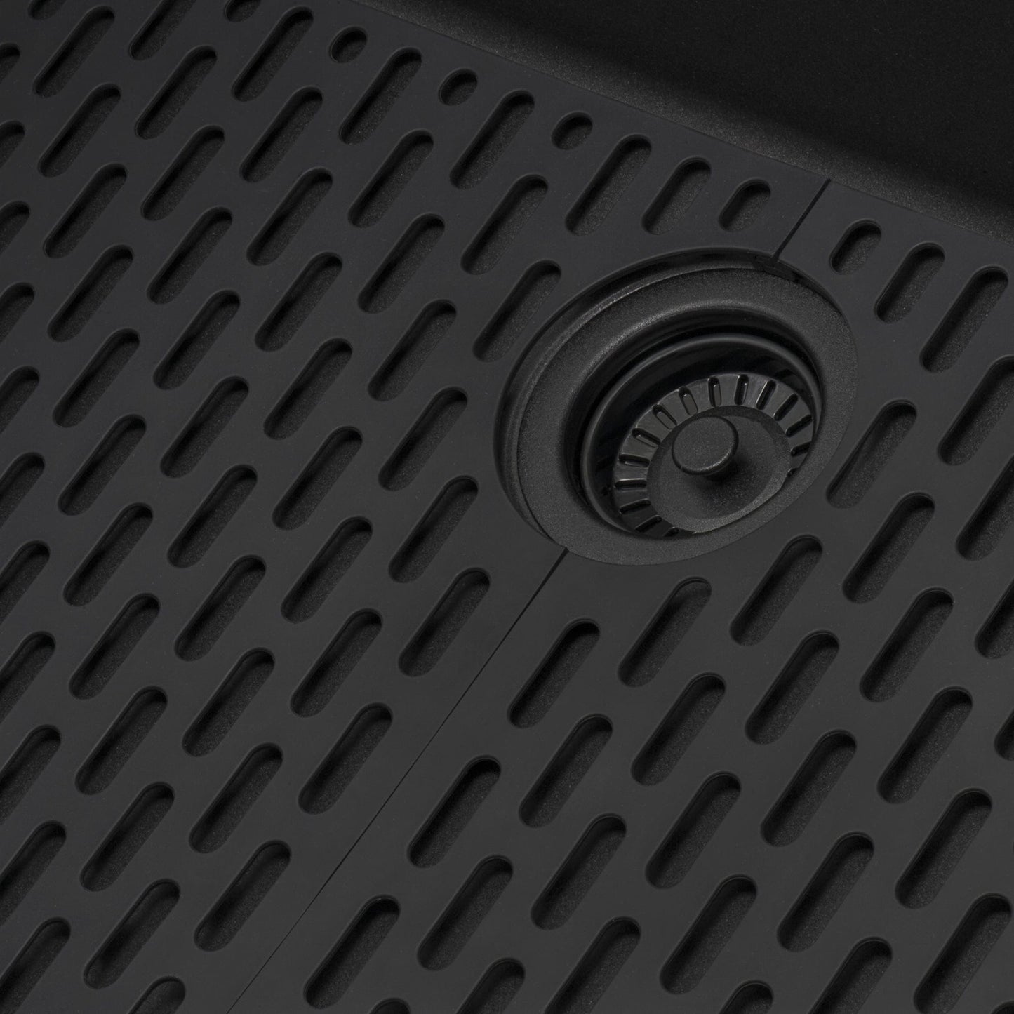 Close-up of Ruvati epiStage 33" Workstation Granite Kitchen Sink RVG2302BK's textured black surface and drainage system.