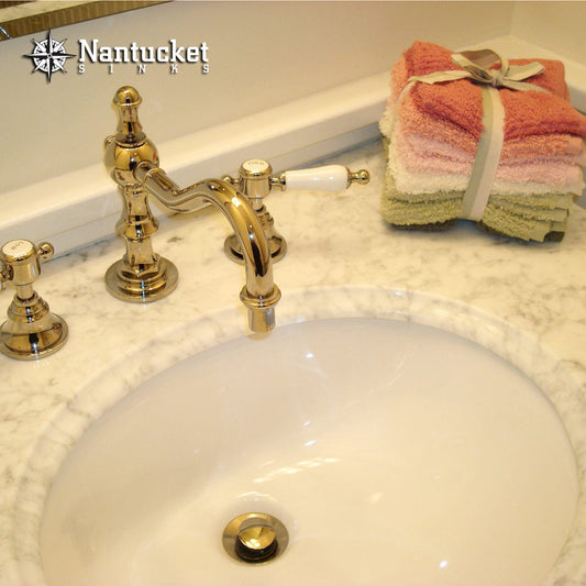 Nantucket 17" Undermount Ceramic Bathroom Sink UM-17x14-W-K with a stylish faucet and stacked towels.