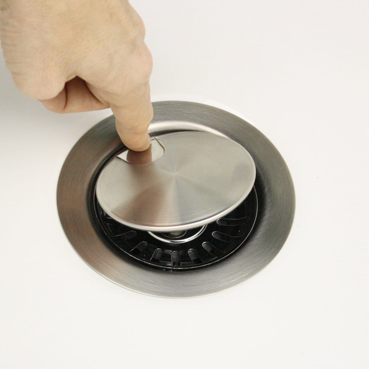 Nantucket Flip Top Crumb Cup Inch Kitchen Drain - NS35LCC with stainless steel lid being pressed.