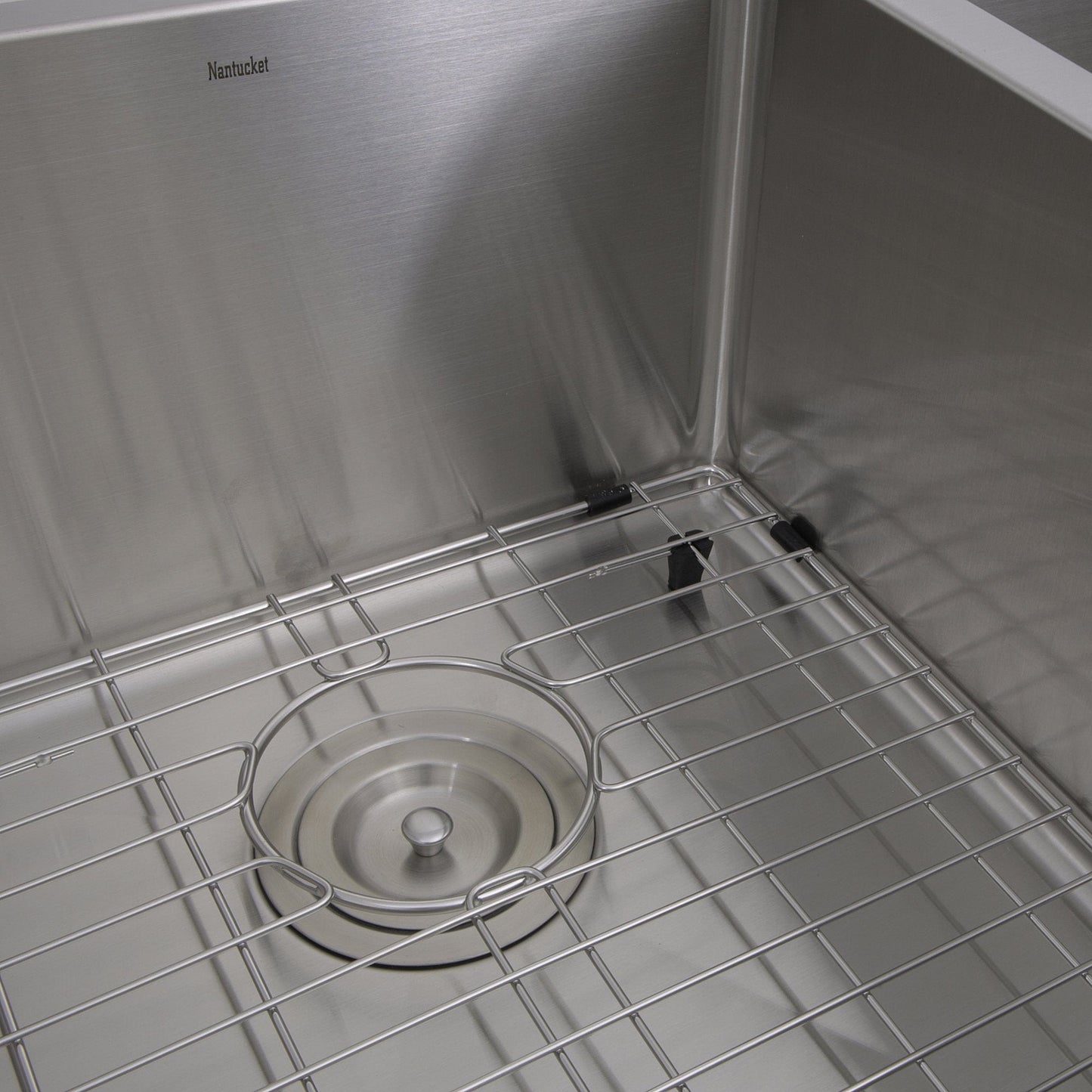 Close-up view of the Nantucket 33" Double Bowl Farmhouse Apron Front Stainless Steel Kitchen Sink - APRON332210-DBL-SR with grid and drain.