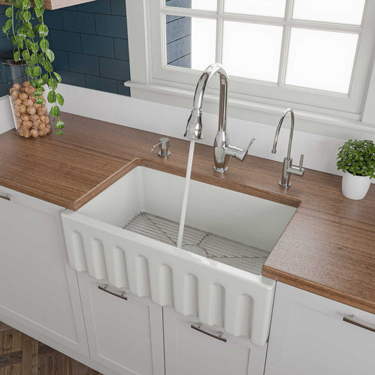 ALFI 30" White Reversible Fireclay Farmhouse Sink installed in a modern kitchen with a wooden countertop.