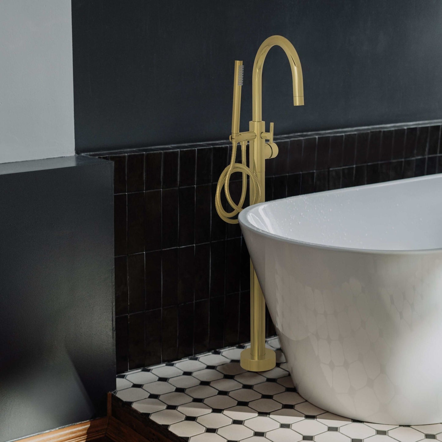 ZLINE Emerald Bay Bath Tub Filler with stylish design next to a modern freestanding bathtub